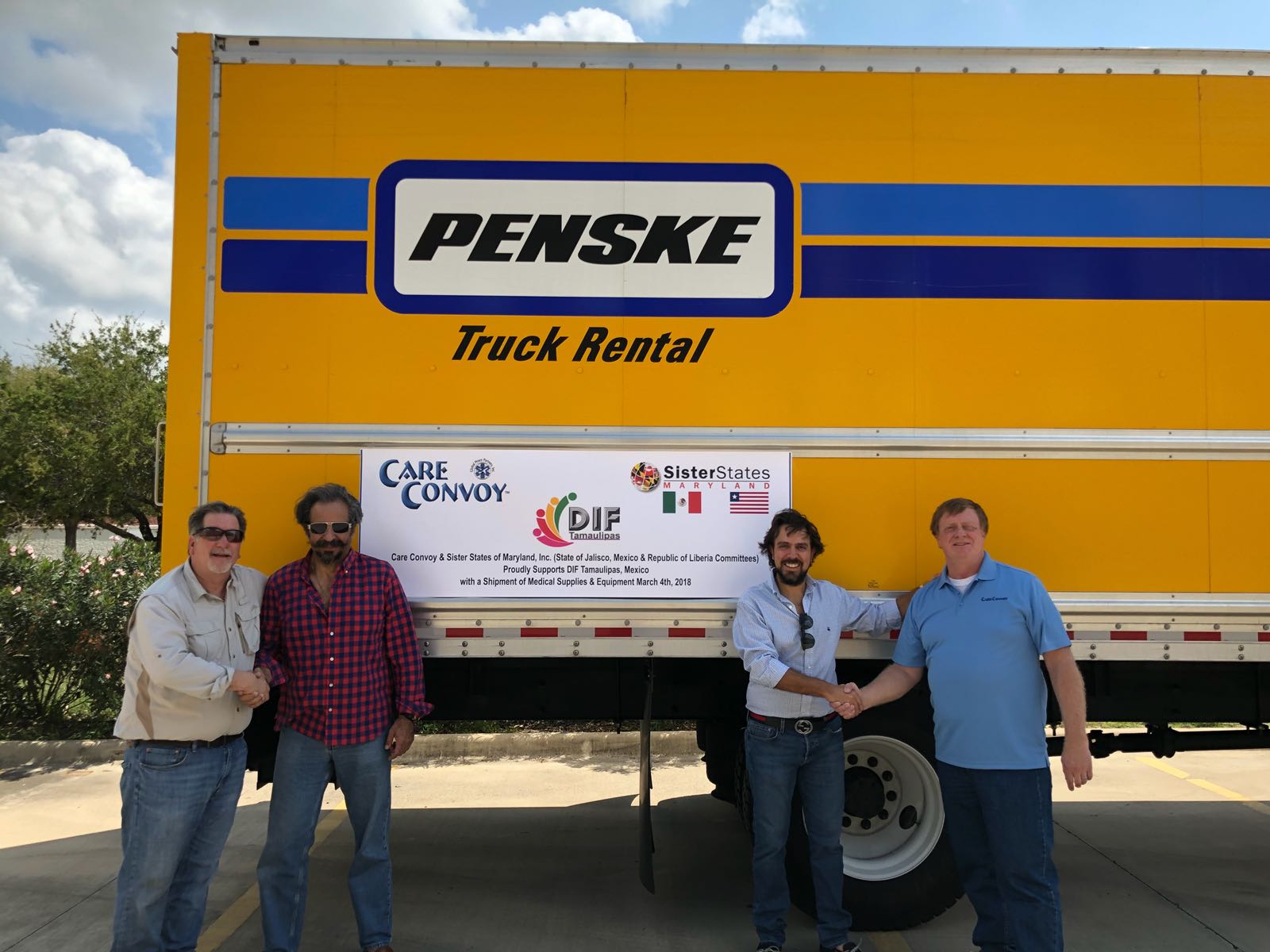 Care Convoy and Maryland Sister State representatives pose in front of their sign and a rental truck with a shipment of medical supplies to Tamaulipas, Mexico
